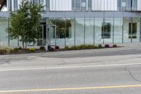 a building with a glass facade on a city street corner with cars parked outside it