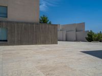 the gray concrete walls of a building have a line of steps on the left side