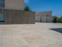 the gray concrete walls of a building have a line of steps on the left side