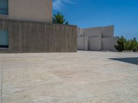 the gray concrete walls of a building have a line of steps on the left side