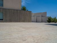 the gray concrete walls of a building have a line of steps on the left side