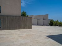 the gray concrete walls of a building have a line of steps on the left side