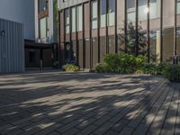 a brick walk way in front of a building and a green sign on the side