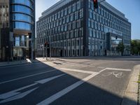 an empty street with large modern office buildings near by at a crossroad in europe