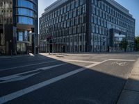 an empty street with large modern office buildings near by at a crossroad in europe