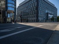 an empty street with large modern office buildings near by at a crossroad in europe