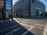 an empty street with large modern office buildings near by at a crossroad in europe