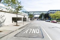 an empty street is next to a walkway in an industrial area that is on the corner and no one is on