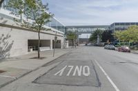 an empty street is next to a walkway in an industrial area that is on the corner and no one is on