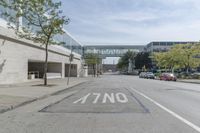 an empty street is next to a walkway in an industrial area that is on the corner and no one is on