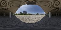 a view through the bottom of a circular object in a large square area, which appears to be a beach