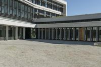 the building has windows and glass doors on both sides of the walkways with a red fire hydrant on each side of it