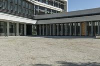 the building has windows and glass doors on both sides of the walkways with a red fire hydrant on each side of it