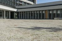 the building has windows and glass doors on both sides of the walkways with a red fire hydrant on each side of it