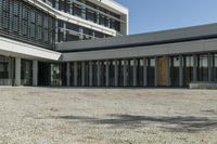 the building has windows and glass doors on both sides of the walkways with a red fire hydrant on each side of it