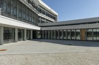 the building has windows and glass doors on both sides of the walkways with a red fire hydrant on each side of it