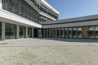 the building has windows and glass doors on both sides of the walkways with a red fire hydrant on each side of it