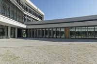 the building has windows and glass doors on both sides of the walkways with a red fire hydrant on each side of it