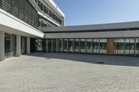 the building has windows and glass doors on both sides of the walkways with a red fire hydrant on each side of it