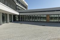 the building has windows and glass doors on both sides of the walkways with a red fire hydrant on each side of it