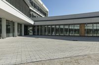 the building has windows and glass doors on both sides of the walkways with a red fire hydrant on each side of it