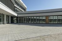 the building has windows and glass doors on both sides of the walkways with a red fire hydrant on each side of it