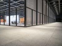 an open room with some furniture and some chairs in the middle of it, with glass wall and windows on both sides