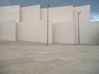 empty area outside concrete building with no people or vehicles at the entrance to area behind it