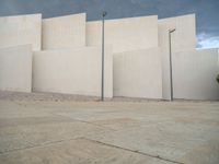 empty area outside concrete building with no people or vehicles at the entrance to area behind it