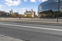 a street with an intersection in front of a building that looks like a glass - walled structure