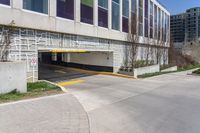 a parking garage entrance with yellow and purple painted on it's sides and a building in the background