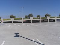 a large parking garage with several spots on the ground and cars parked in rows and one standing