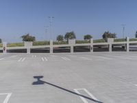 a large parking garage with several spots on the ground and cars parked in rows and one standing