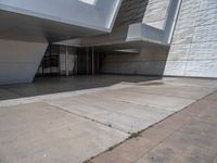 a white building with several steps and large glass panels in the facade is a mosaic that depicts a man