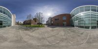 a spherical view of a public building and parking lot at dusk with no cars on the street