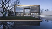 the pool and grass have been freshly cut for this modern residence near an apartment block