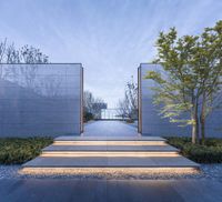 a walkway leads to a building and the building has stone walls and a lighted door