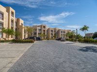 the driveway in the front of this block has several buildings with a parking space next to it