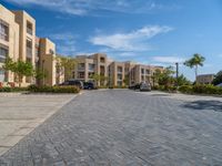 the driveway in the front of this block has several buildings with a parking space next to it