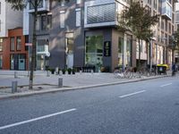 an empty city street with buildings and a bike parked on the sidelines of the street