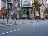 an empty city street with buildings and a bike parked on the sidelines of the street