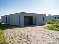 the three houses are made of concrete and a garage is designed to have an open - air roof