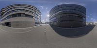 a fish eye lens shows two buildings in the middle of a street with buildings across it