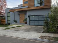 a very neat modern home is on the street corner in front of the house, looking into the road