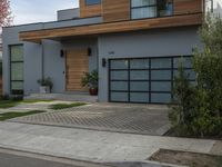 a very neat modern home is on the street corner in front of the house, looking into the road