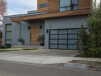 a very neat modern home is on the street corner in front of the house, looking into the road