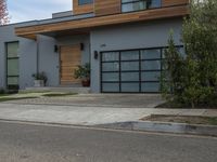 a very neat modern home is on the street corner in front of the house, looking into the road