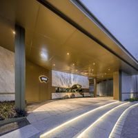 a hotel entrance has a large sculpture under the awning that's lighted up at night