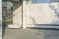 a black skateboarder on a concrete slab under an umbrella and a big white fence