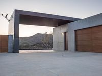 an outside garage door with mountains in the background and a couple of lights above it